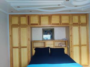 a bedroom with wooden cabinets and a blue bed at Duplex Elias in Marrakesh