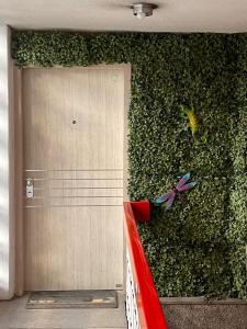 uma parede verde com uma porta em frente a uma planta em Apartamento movistar Arena-Estadio El Campin-galerías con garaje 2 a 6 personas em Bogotá