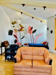 sala de estar con sofá y mural en Departamento para vacacionar, en Tepic
