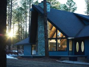 a blue house with the sun shining through the windows at Cobalt Cabin Gateway to Grand Canyon Sedona & More in Williams