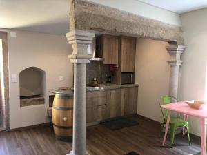 uma cozinha com uma mesa e um barril de vinho em Casas do Solar - Guest House - em Almeida