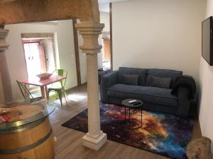 uma sala de estar com um sofá e uma mesa em Casas do Solar - Guest House - em Almeida