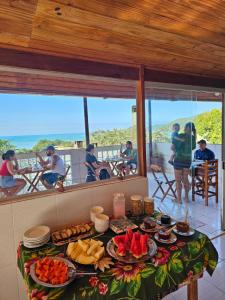 einen Tisch mit Essen und Meerblick in der Unterkunft Pousada Encontro das Águas in Trindade