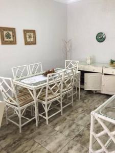 uma mesa branca e cadeiras numa cozinha em Apartamento em Guarujá no Guarujá