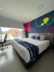 een slaapkamer met een groot bed en een kleurrijke muur bij Agora Suites Self-Service Boutique Hotel in Bogota