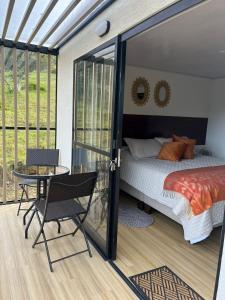 1 dormitorio con 1 cama, mesa y sillas en Villa Dante, en Firavitoba