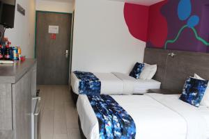 a hotel room with two beds and a kitchen at Agora Suites Hotel, Check-in digital fácil con atención virtual 24h in Bogotá