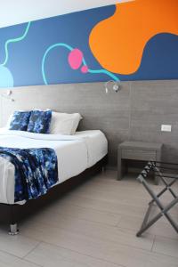 een slaapkamer met een bed met een kleurrijke muur bij Agora Suites Self-Service Boutique Hotel in Bogota