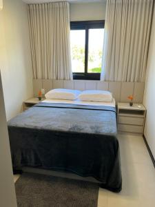 a bedroom with a large bed with a window at Praia do forte - Villa do lago in Praia do Forte