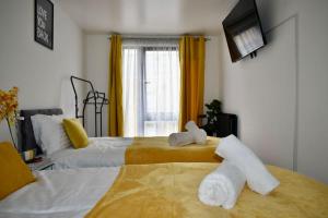 een hotelkamer met 2 bedden en handdoeken bij Tottenham Hotspurs Stays at the Gascoigne Suite in Londen
