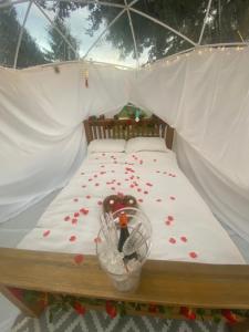 a bed in a tent with red flowers on it at Country Bumpkins Luxury Igloo in Wellingore