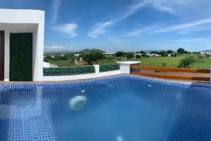 a swimming pool in front of a house at Casa More con alberca, jacuzzi, climatizada in Tequesquitengo