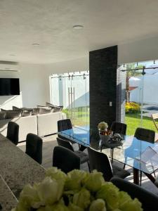 uma sala de jantar com mesa e cadeiras e um quarto com janelas em Casa More con alberca, jacuzzi, climatizada em Tequesquitengo