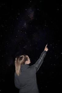 a woman pointing at the stars at night at Cabaña Abra Del Monte in Cachí