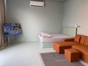 a small room with a couch and a tv at Alley51 Hotel in Surat Thani