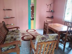 a dining room with a table and chairs at Ian Creole Garaden Cottages in Roseau