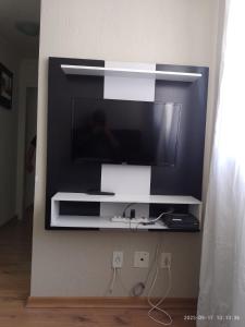 a flat screen tv on a wall in a room at Ap ótima localização in São José dos Campos