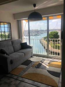 a living room with a couch and a view of a harbor at Agde : appartement vue sur le port in Cap d'Agde