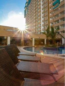 a balcony with chairs and a pool in a building at Flat no Olimpia Park Resort (ao lado do Thermas dos Laranjais) in Olímpia