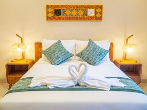 una camera da letto con un letto con due asciugamani e due lampade di Arumasta Ubud ad Ubud