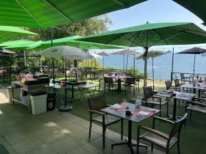 a restaurant with tables and chairs with umbrellas at Hôtel de la Plage à Gland in Gland