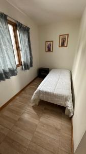 a bedroom with a bed and a tiled floor at Casa Los Ñires Ushuaia in Ushuaia