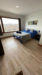 a bedroom with a bed and a large window at Casa Los Ñires Ushuaia in Ushuaia