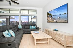 una sala de estar con un sofá y una mesa en Sunshine Coast Dream Getaway, en Pelican Waters