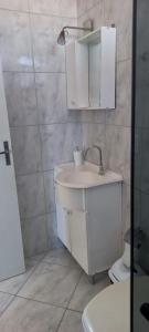 a bathroom with a sink and a toilet and a mirror at Apartamento Praia de Porto Belo, Balneario Pereque, SC in Porto Belo +44 photos