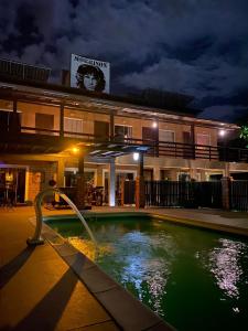 un edificio con piscina por la noche en Pousada Morrison, en Praia do Rosa