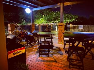 a patio with a table and chairs and a motorcycle parked at Pousada Morrison in Praia do Rosa