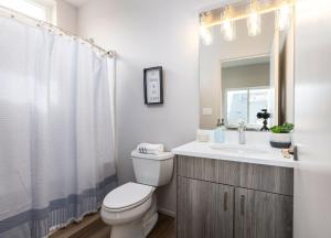 a bathroom with a toilet and a sink and a mirror at Brand New Fully Updated Condo 912 in Anacortes in Anacortes +30 photos