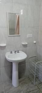 uma casa de banho com um lavatório branco e um espelho. em Villa Arcadia em Sierra de la Ventana