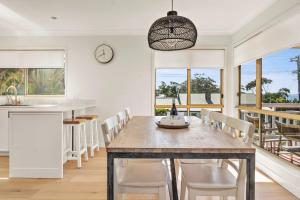 a kitchen and dining room with a table and chairs at On Cyrus at Hyams Beach in Hyams Beach