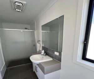 a white bathroom with a sink and a shower at Wallaroo Beachfront Tourist Park in Wallaroo