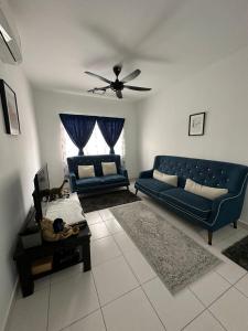 a living room with a blue couch and a table at Khadeeja Karisma in Semenyih