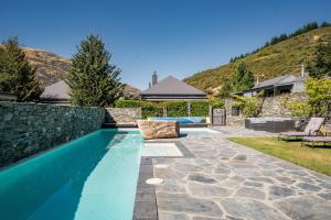 a swimming pool in a yard with a house at Gold Rush Chalet - Cardrona Holiday Home in Cardrona
