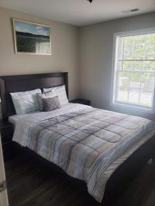 a bedroom with a large bed with a large window at Welcome to our newly built house in Glen Burnie