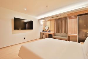 a hotel room with a bed and a television at The Van Stay in Busan