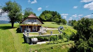 Mirna的住宿－Zerko Holiday Home - Vineyard Chalet With Sauna and Jacuzzi FREE，一座小房子,位于一座小山上,设有花园