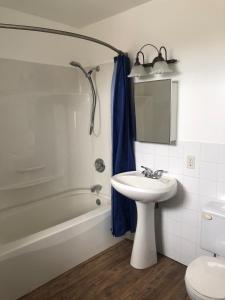 a bathroom with a sink and a tub and a toilet at Inukshuk Rooms in Churchill