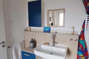 a bathroom with a sink and a mirror at FeWo Harzblickterrasse Goslar in Goslar +23 photos