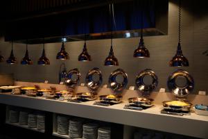 a buffet line with plates of food and lights at J One Hotel Cheongju in Cheongju