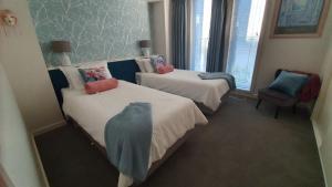 a hotel room with two beds and a chair at Seaside Escape in Mornington