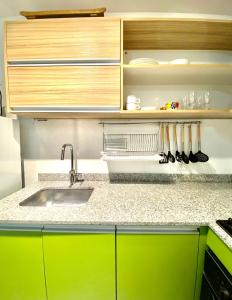 a kitchen with green cabinets and a sink at Cómodo Monoambiente en el Centro de la Ciudad in Concordia