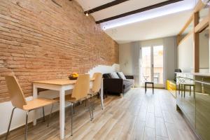 a brick wall in a living room with a table and chairs at Stay Barcelona Gracia Apartments in Barcelona