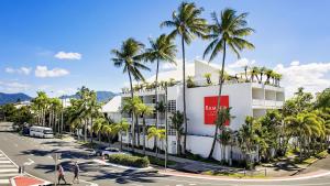 凯恩斯Ramada By Wyndham Cairns City Centre的街道前有棕榈树的建筑
