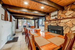 comedor con mesa y chimenea de piedra en Mountain & Ski Slope View Cabin 3bd/3bth Sleeps 10, en Big Bear Lake