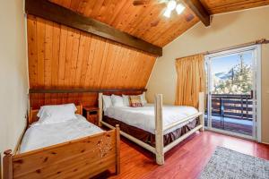 Dos camas en una habitación con ventana. en Mountain & Ski Slope View Cabin 3bd/3bth Sleeps 10, en Big Bear Lake