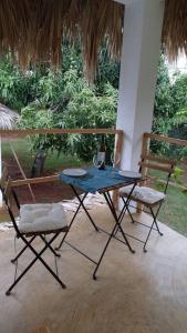 a blue table and two chairs on a porch at Quédate Aquí in Las Galeras